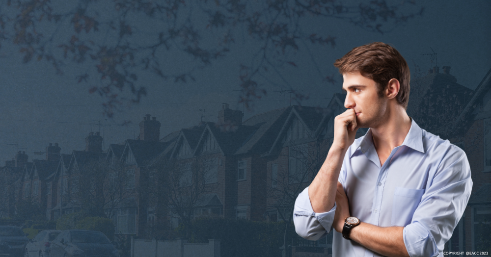 Thoughtful man in front of a street with residential properties. 