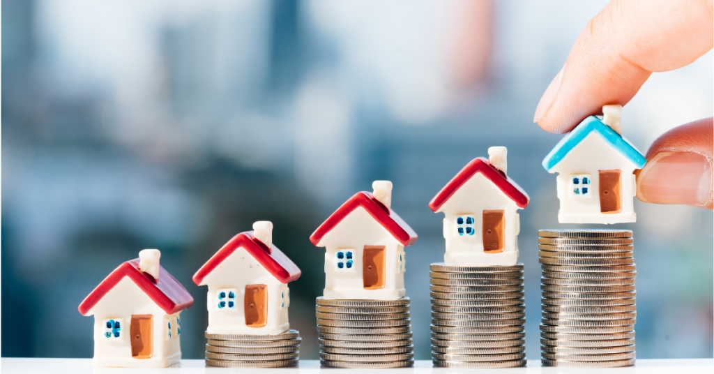 Little house models on top of coins stacks