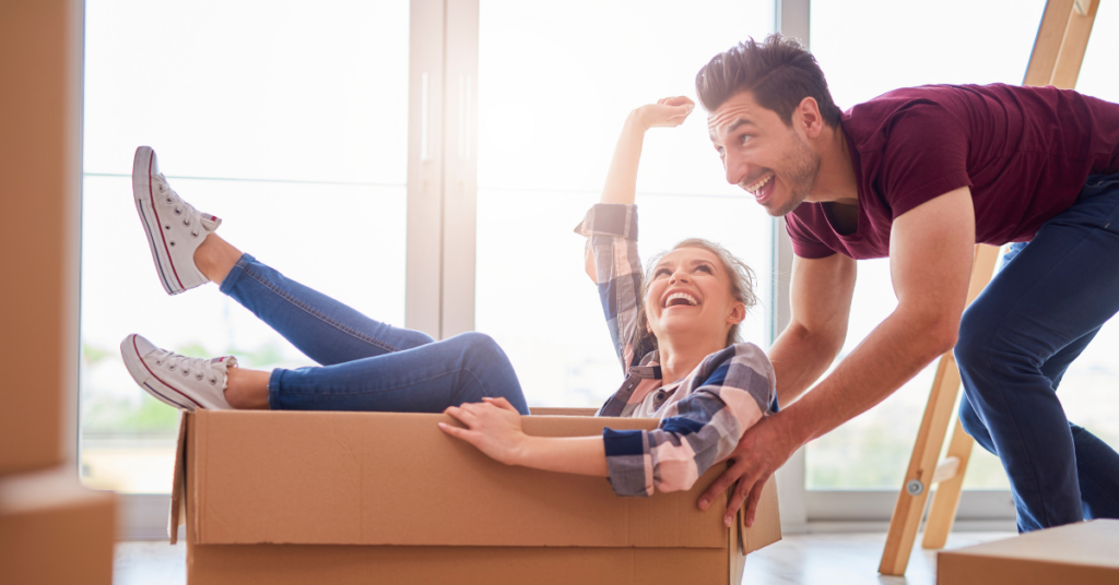 Man pushing woman in a box, while moving together.