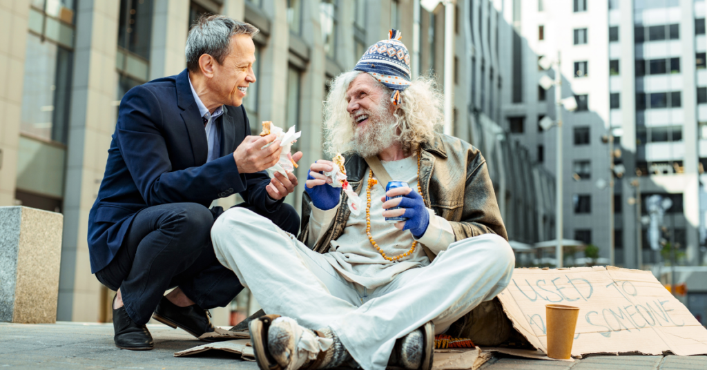 Man smiling and sharing food with a homeless man.