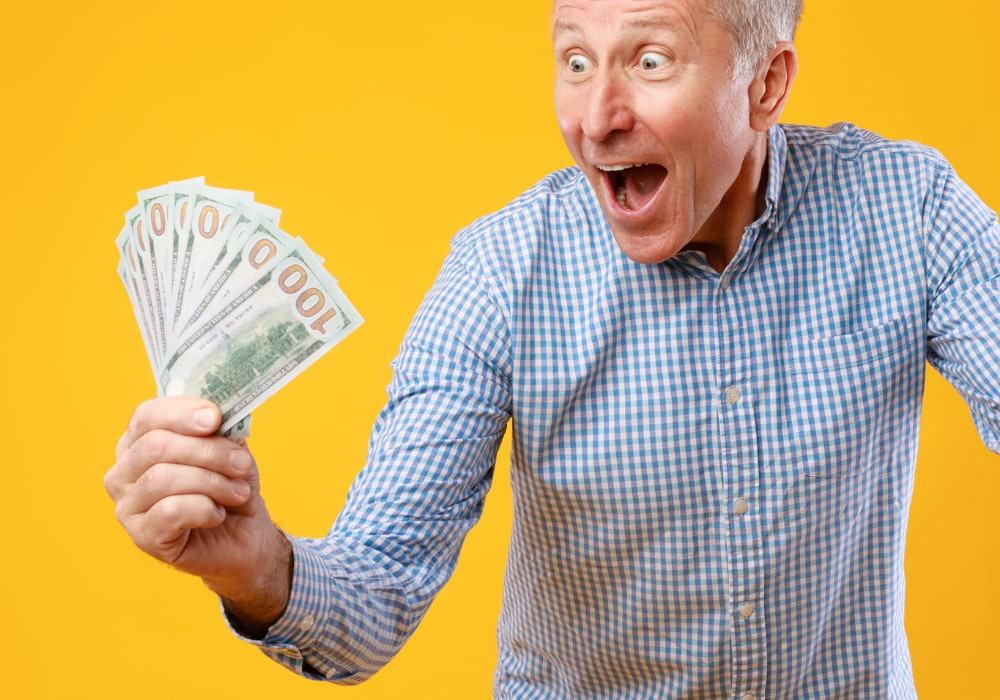 Man holding money looking surprised