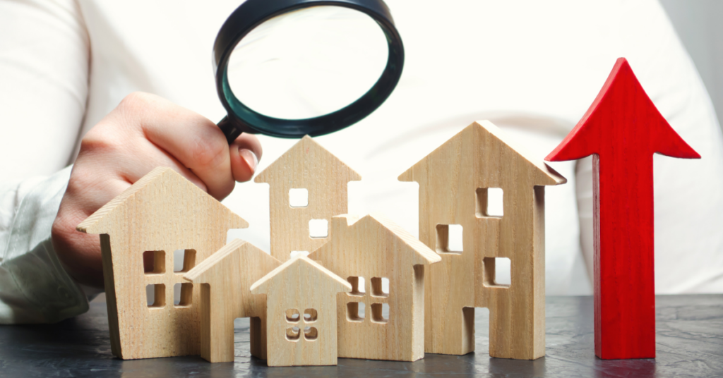 Wooden house models and a man holding magnifier .