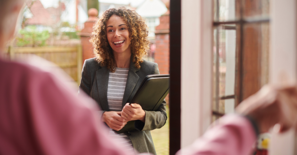 Smiling woman entering a house and greeting a landlord.