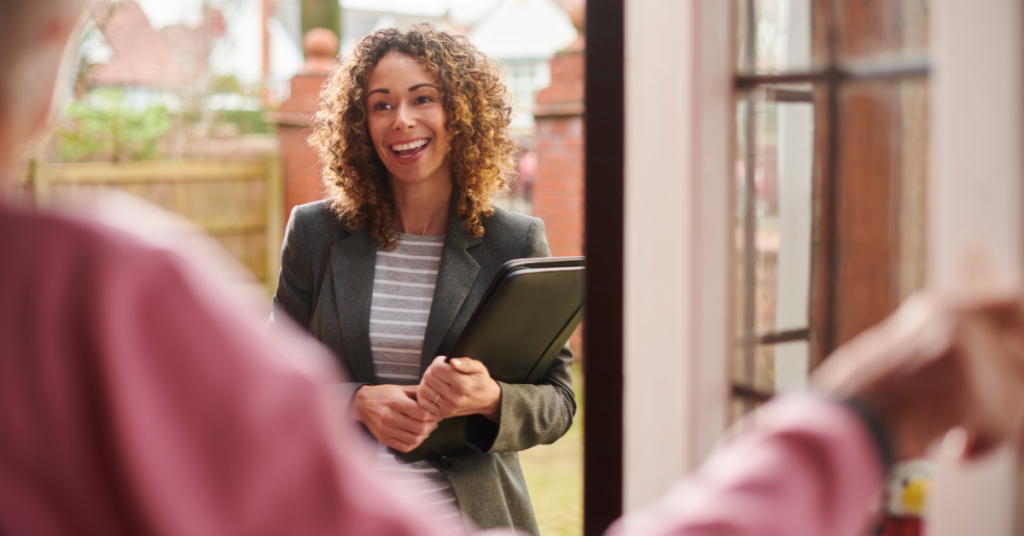 Smiling woman entering a house and greeting a landlord. 