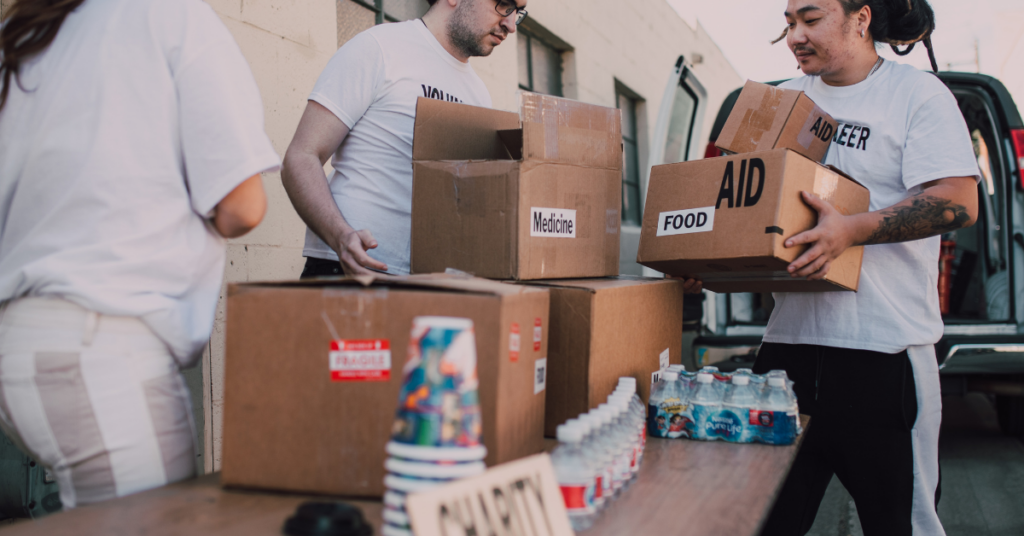 Volunteers are cooperating while sorting donation boxes.