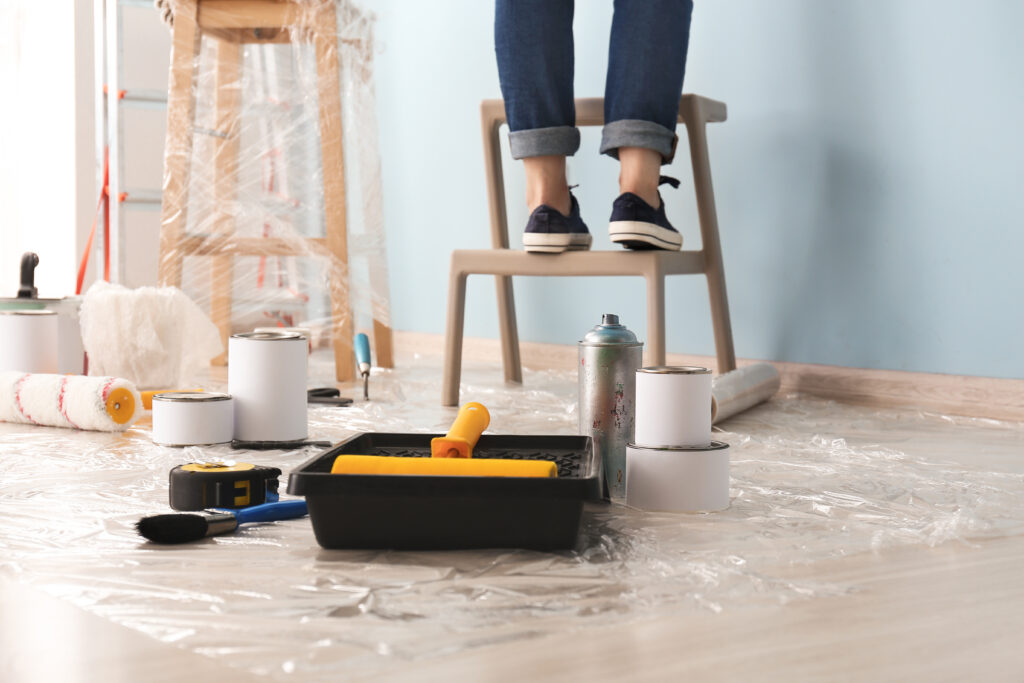 Paints with tray and supplies on floor in room