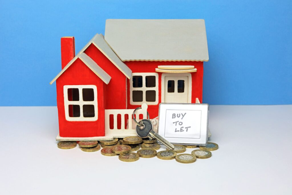 Buy To Let Key Ring And Key Outside A Scale Model Home. Buy To Let Income Concept.