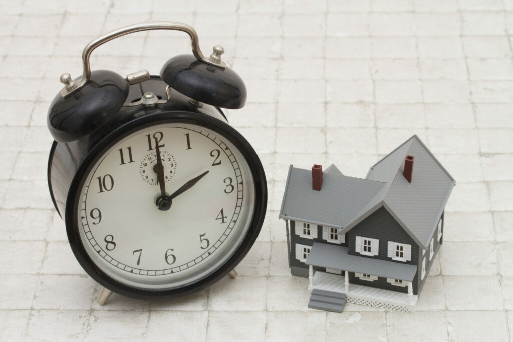 How Long Will It Take For My Swansea House Sale To Go Through? Clock by house. Expert advise from Swansea estate agents.