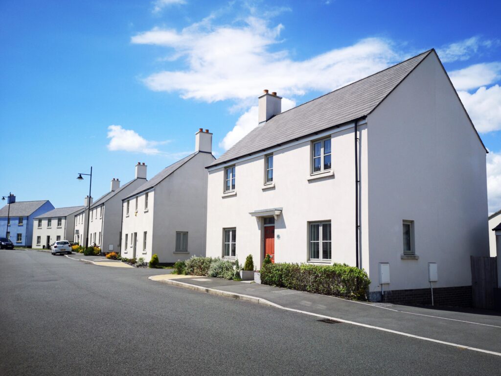New large double fronted four bedroom detached houses built on reclaimed land formerly an industrial area in UK. Street view with diminishing perspective.