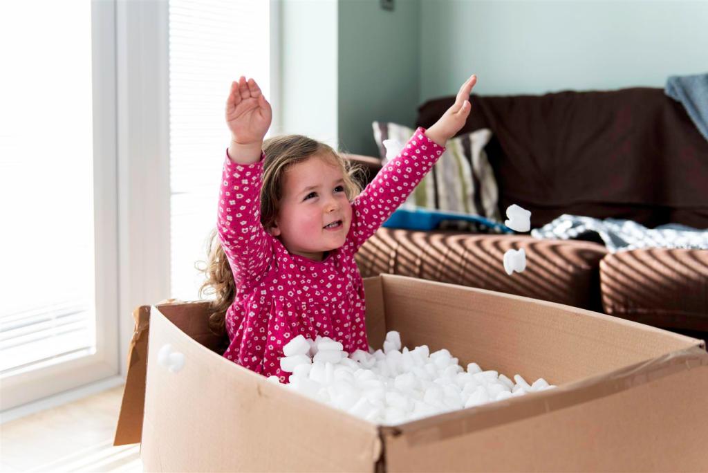 A child playing in a box at a new home A child playing in a box at a new home