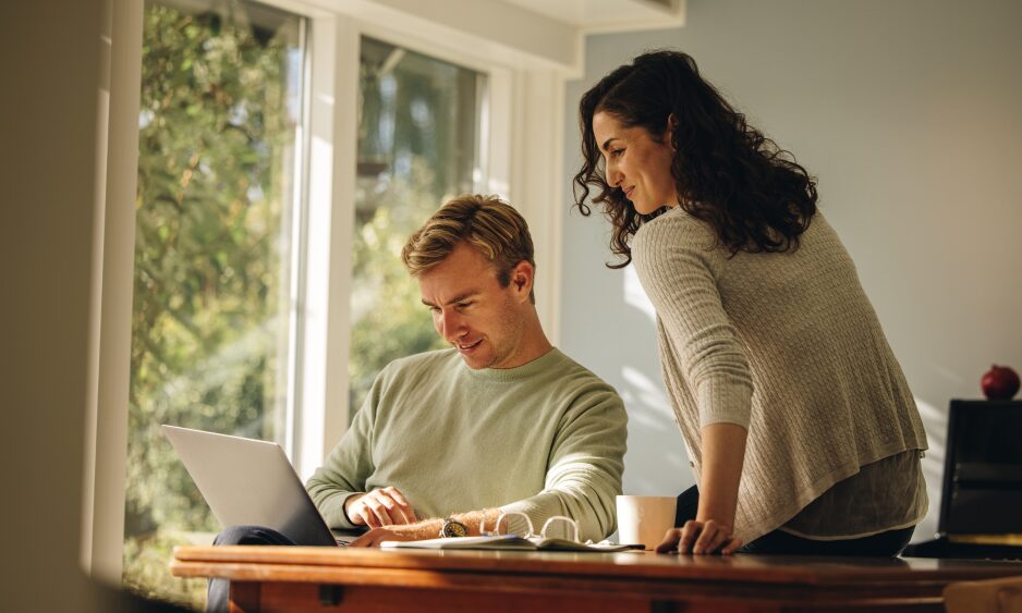 Couple reviewing property investment options on a laptop at home, representing rental property investment in Morley, West Yorkshire.