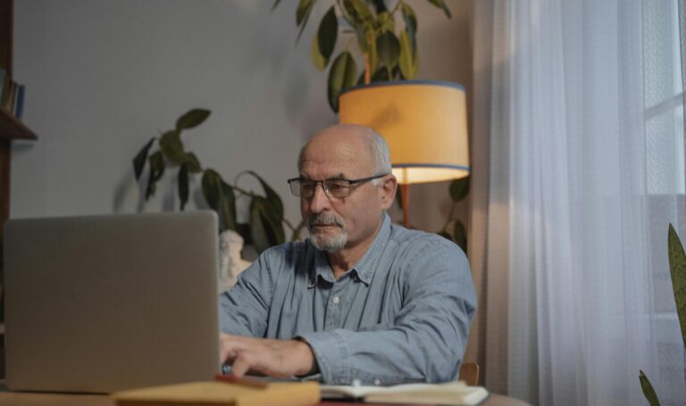 Landlord reviewing tenant applications on laptop at home
