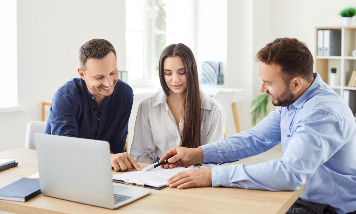 Estate agent reviewing property details with couple during consultation in Mumbles SA3