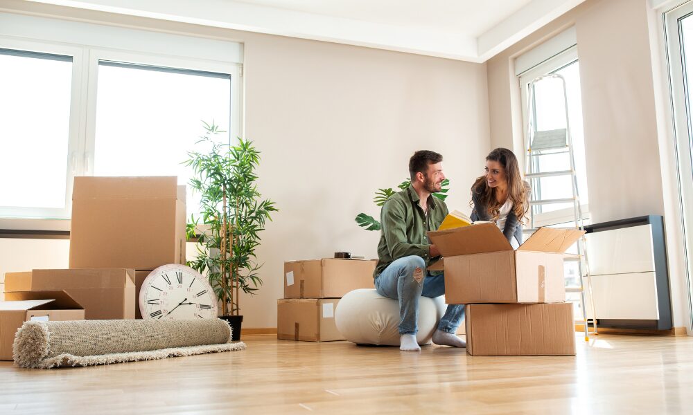 Young couple unpacking boxes in their new home representing first-time buyers in Wolverhampton