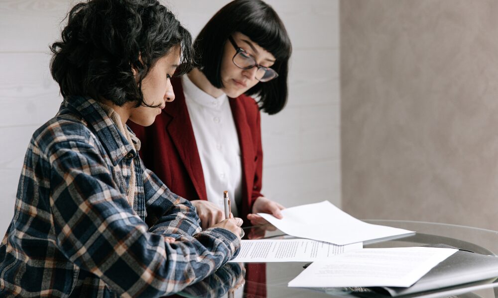 Landlord reviewing rental agreement with letting agent at a table