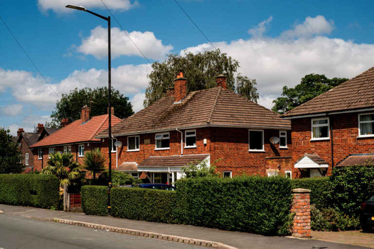 Row of red-brick semi-detached houses in Cannock with front gardens and driveways