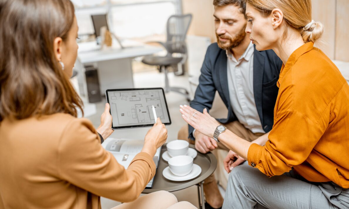 Estate agent reviewing property layout with couple during consultation in Tadley RG26