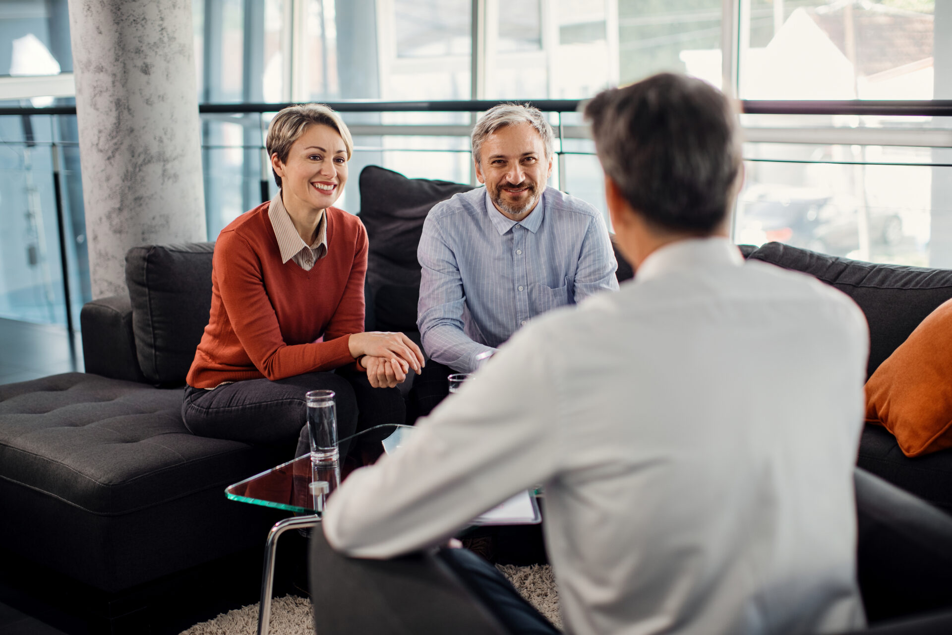 landlord meeting with tenants discussing tenancy terms and rent structure in a modern living room