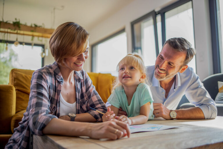 Family sitting together at a table drawing and discussing their new home in Inverness Image Title: inverness-family-home-choice