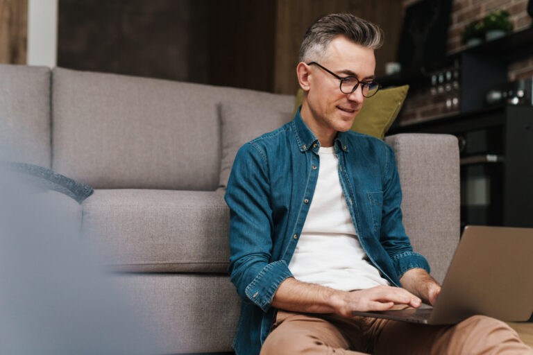 Landlord using a laptop at home reviewing property security and rental management