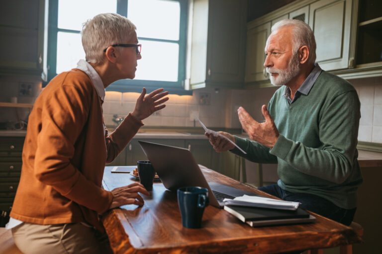 Couple reviewing paperwork at a kitchen table discussing house purchase in Shrewsbury school catchment area