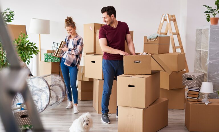 Young couple unpacking moving boxes in a modern Guiseley rental property in LS20