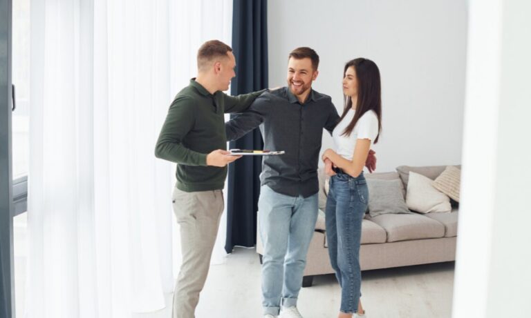 Estate agent presenting a property to a couple inside a modern home in Cambridge CB4