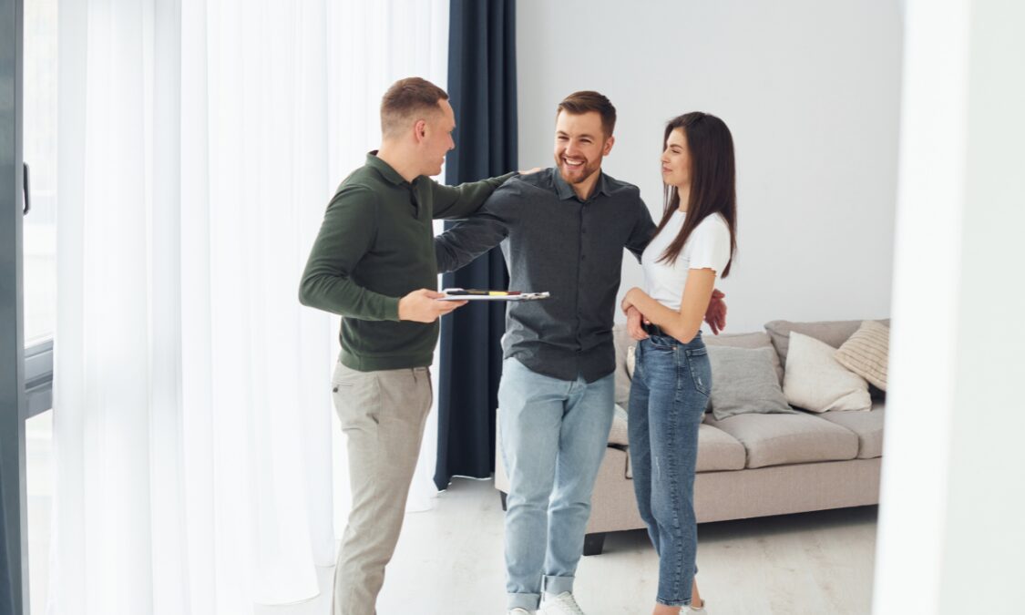 Estate agent presenting a property to a couple inside a modern home in Cambridge CB4