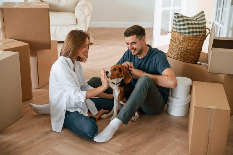 Young couple with their dog moving into a new rental property in Wolverhampton surrounded by moving boxes