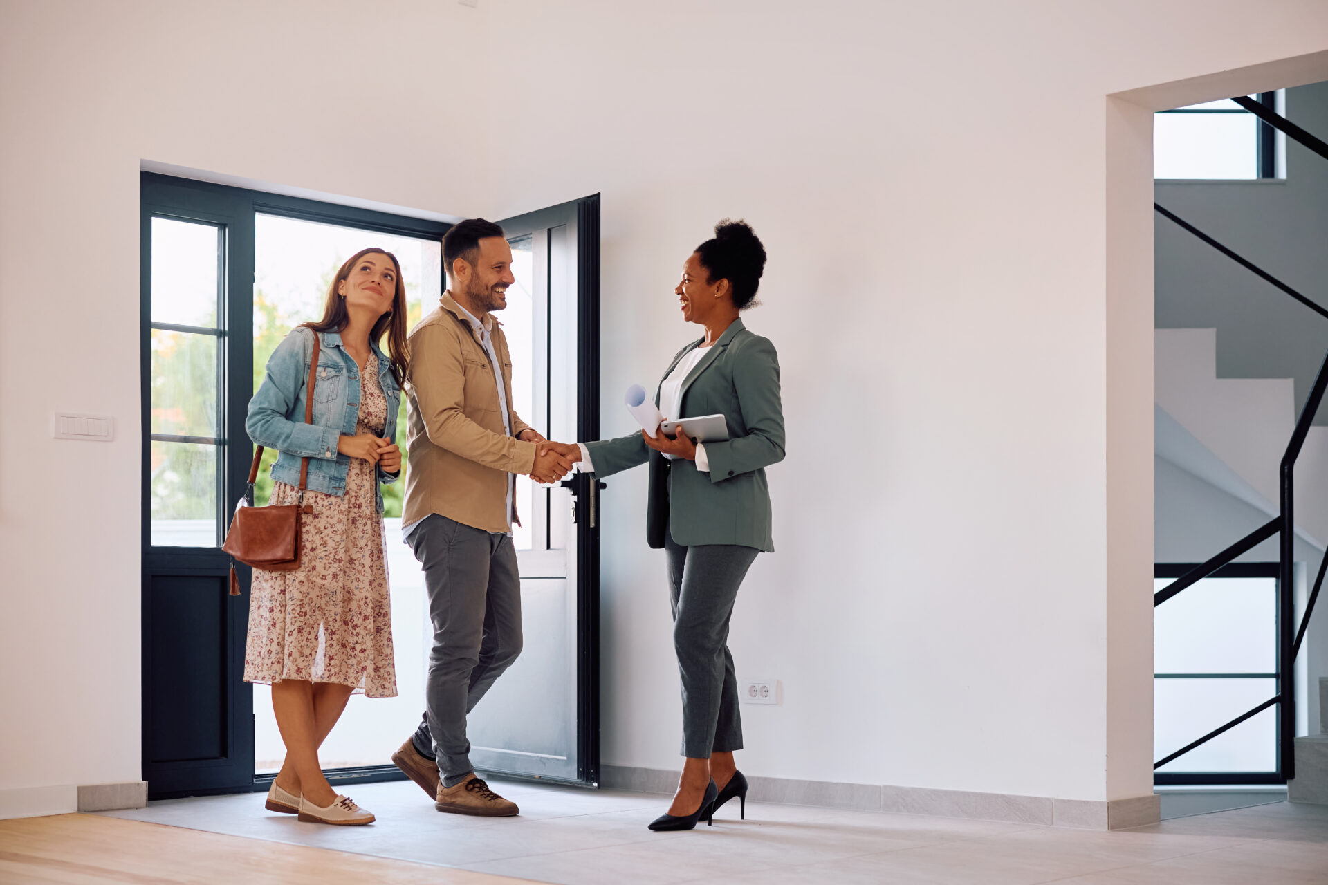 Estate agent greeting a couple inside a modern home, representing St Helens rental demand and landlord opportunities in 2026.