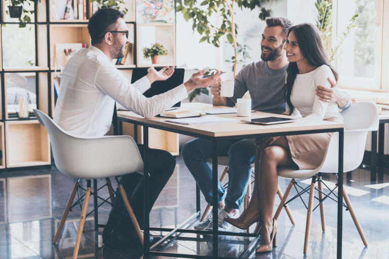 Property adviser speaking with a couple at a desk, representing Brighton rental yields and buy-to-let investment guidance.