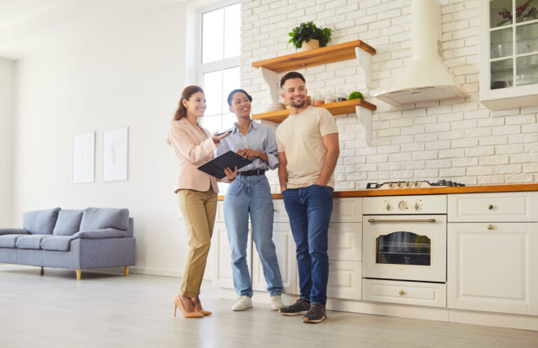 Estate agent showing buyers around a bright modern kitchen, representing Cambridge East property prices and buyer demand.