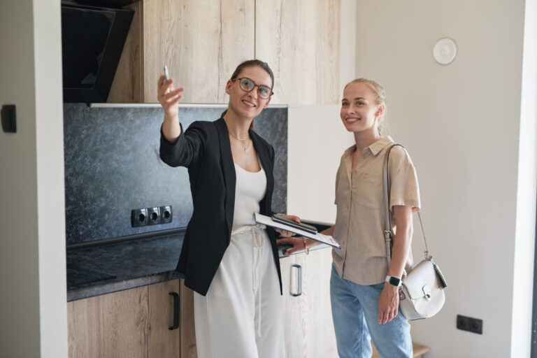 Estate agent showing a buyer around a modern kitchen, representing affordable homes to buy in Cardiff under £225k.