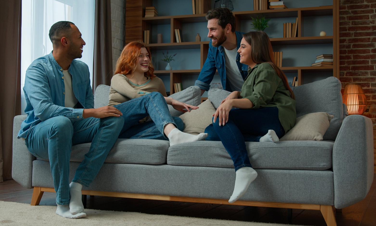 Group of young adults relaxing together in a shared rental property, illustrating house in multiple occupation living in Huntingdon