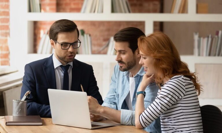 Estate agent discussing property options with a couple using a laptop during a home buying consultation, reflecting the expert guidance available for buyers and renters considering living in Caversham RG4.