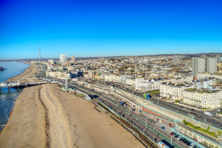 Aerial view of Brighton seafront near Kemp Town BN2, showing the beach, promenade, Regency architecture, residential properties, and coastal skyline.