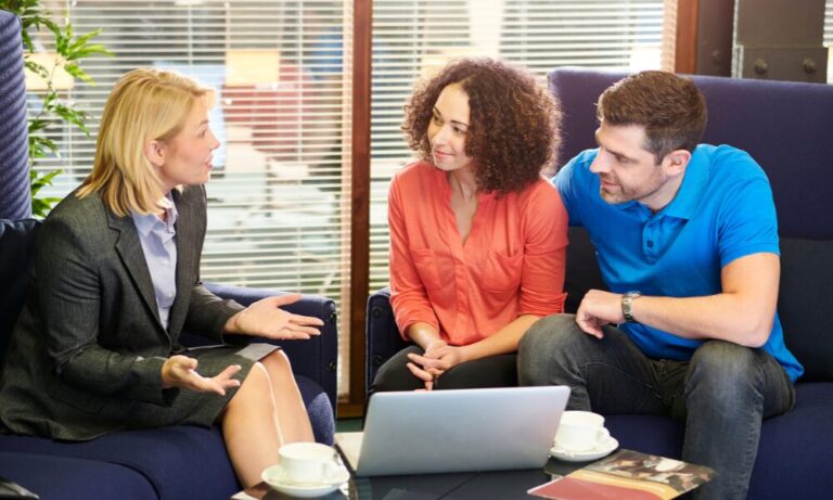 Estate agent meeting with a couple to discuss property options using a laptop, reflecting the expert guidance available for buyers, renters and landlords considering living in WS1 Walsall.