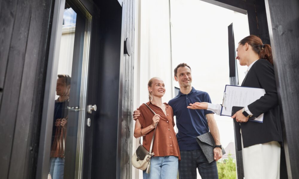 Letting agent welcoming a couple to a property viewing at the front door of a modern home, representing the rental opportunities and professional lettings services available across Mid-Cheshire, including Northwich, Winsford, Middlewich, Holmes Chapel, Congleton, Sandbach and Knutsford.