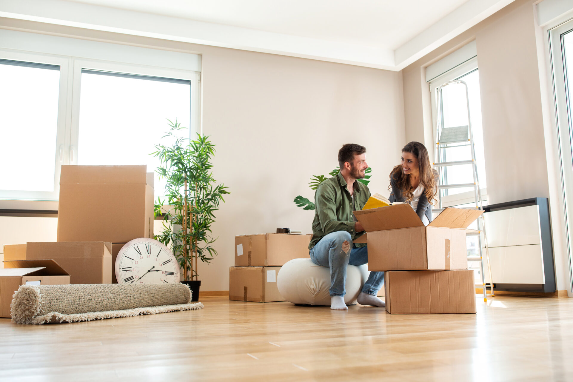 Couple unpacking boxes in a bright home, representing downsizing and moving to a smaller property in Shrewsbury.