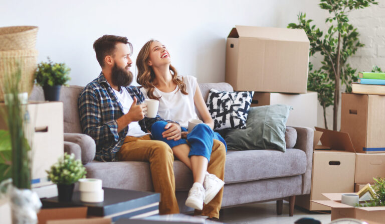 Couple sitting among moving boxes in their new home, representing family buyers moving to St Helens.