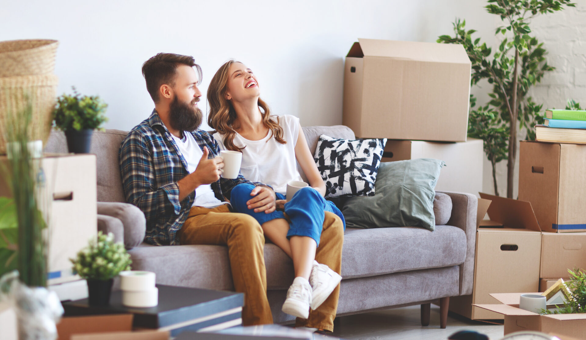 Couple sitting among moving boxes in their new home, representing family buyers moving to St Helens.