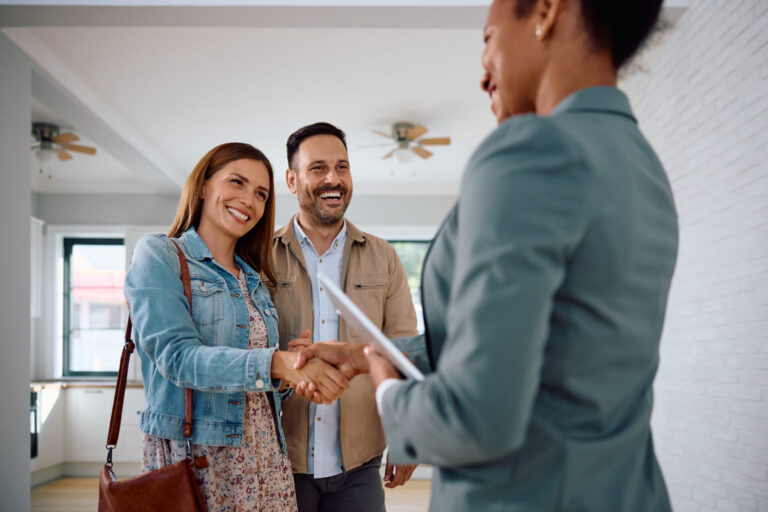Estate agent shaking hands with a couple inside a rental property, representing Tadley landlord opportunities and AWE contractor lets.