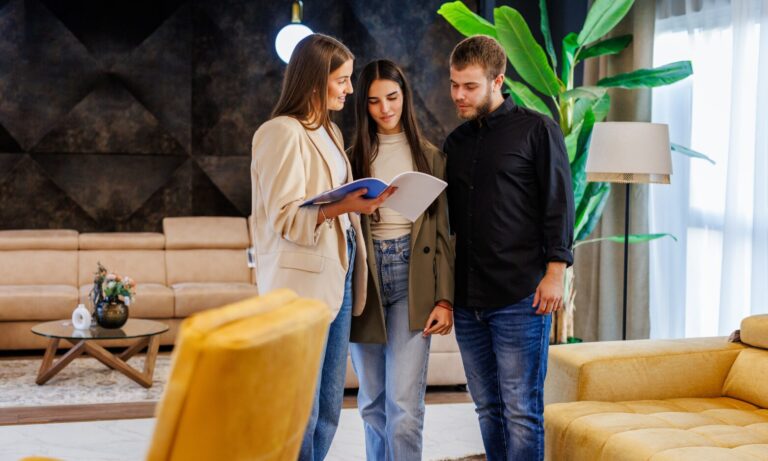 A letting agent showing property documents to a couple during a rental property viewing in Stafford.