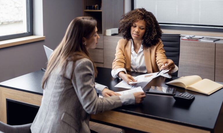 Property professional discussing compliance documents with a landlord, representing Renters’ Rights Act guidance for Warrington rental properties.