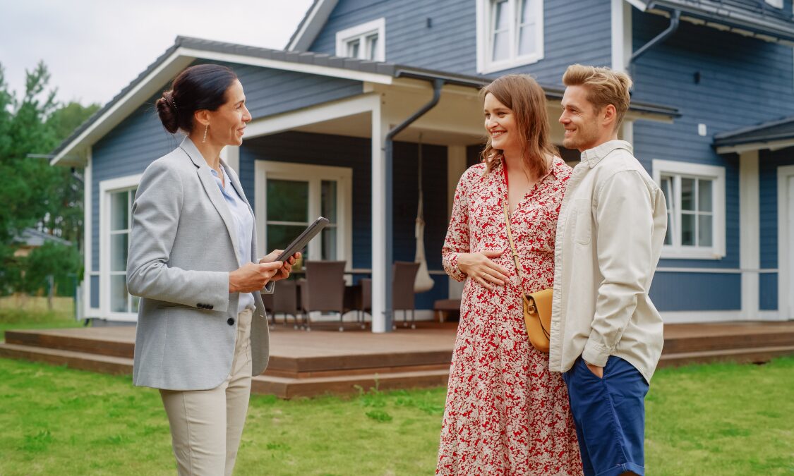 Estate agent speaking with a couple outside a modern family home in Great Sankey, WA5.