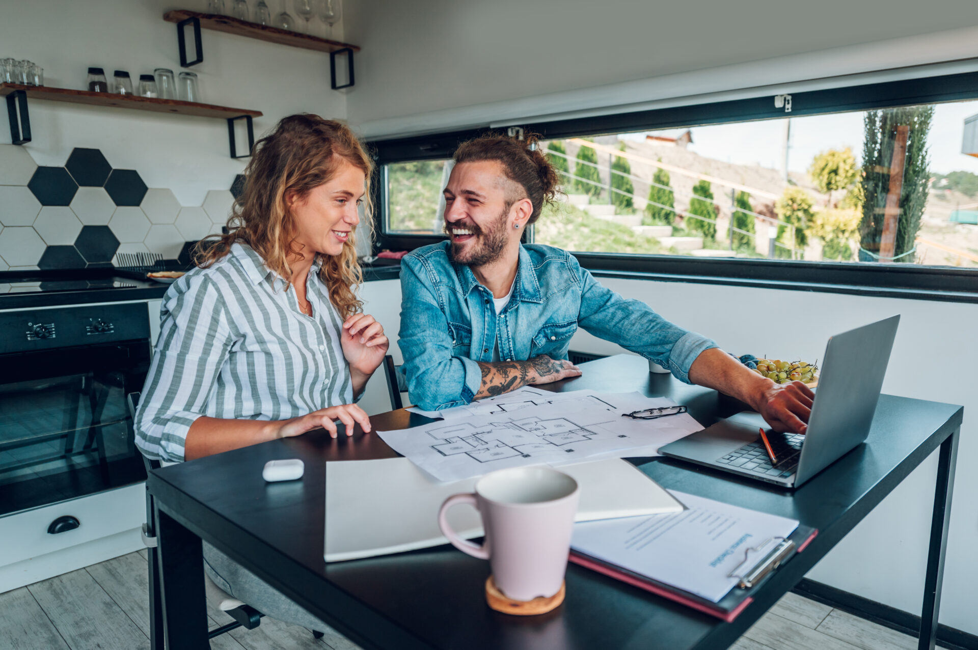Couple reviewing house plans together at home, representing buyers planning a move to Sketty SA2 in Swansea.