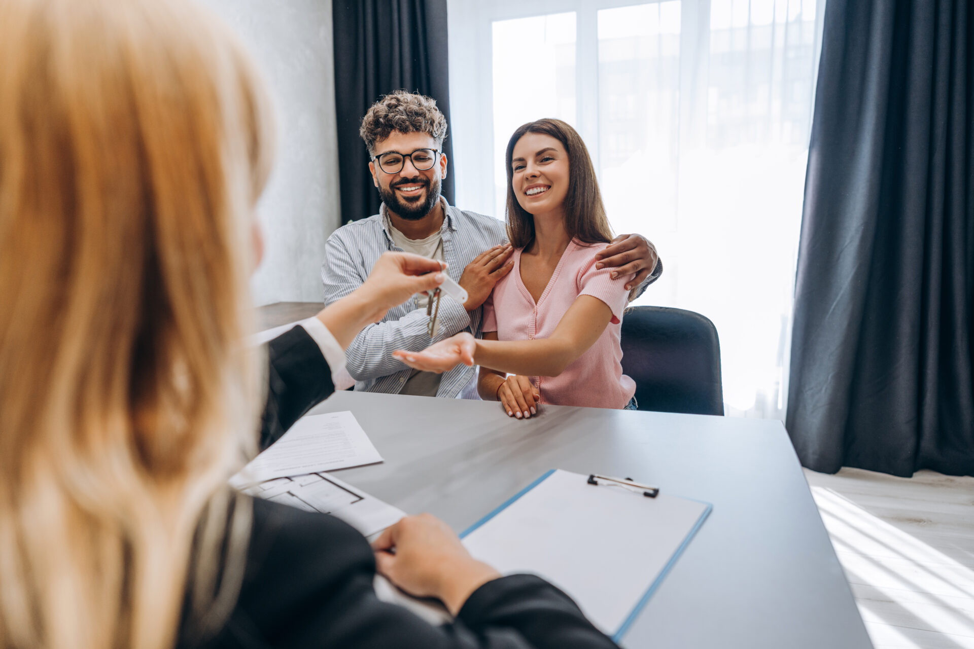 Couple receiving property keys from a letting agent during a rental meeting