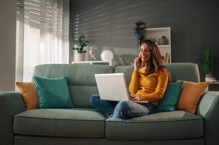 Homeowner using a laptop to research the Tilehurst property market before deciding whether to sell her home.