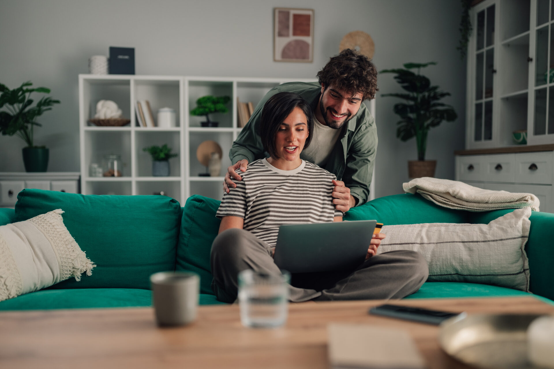Couple browsing rental property information on a laptop while relaxing at home