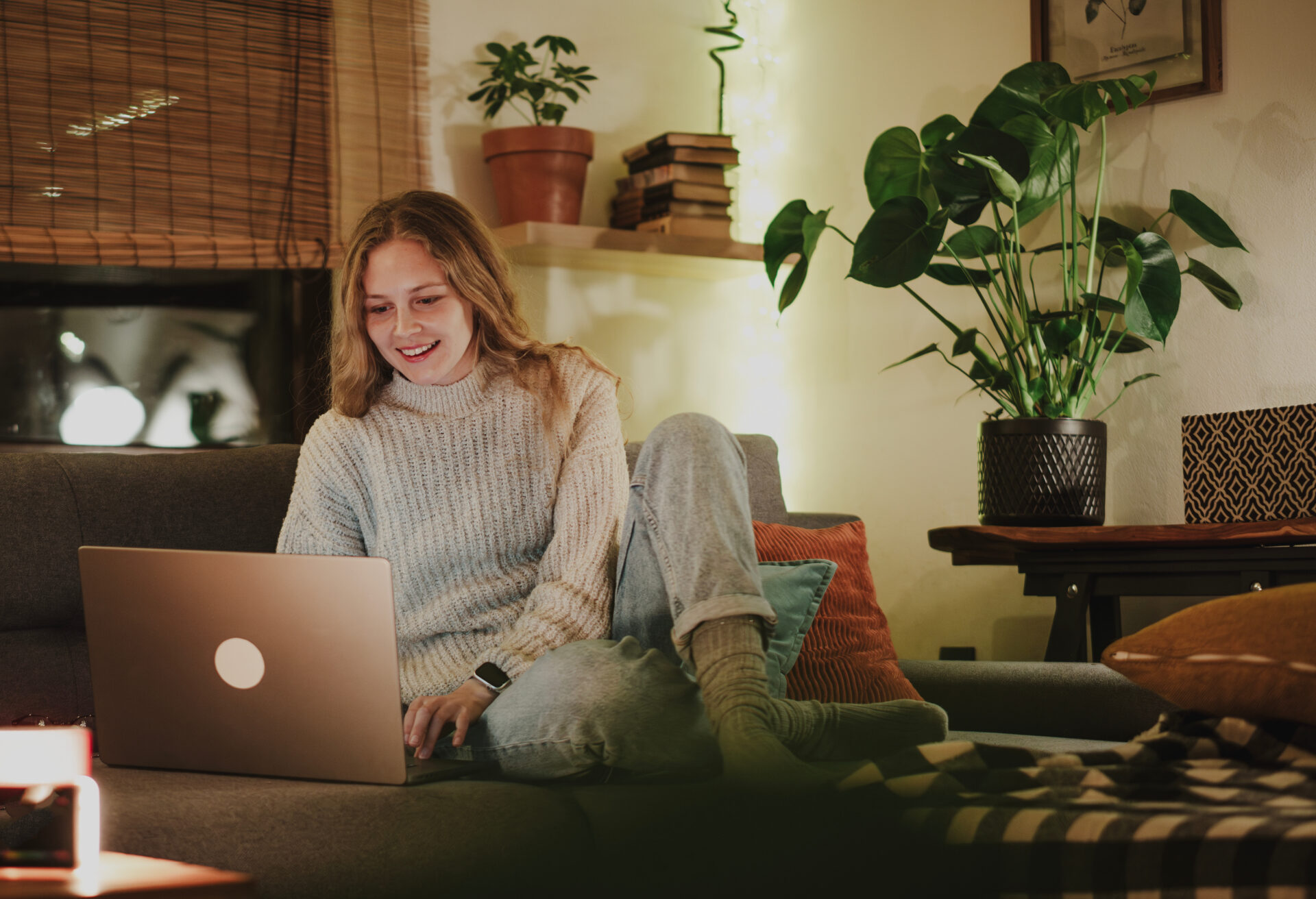 Woman using a laptop while relaxing at home in Killay, Swansea